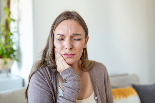 woman holding jaw in pain kneib dentistry