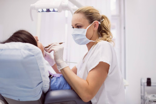 dentist performing exam of patient's mouth kneib dentistry what is a frenectomy